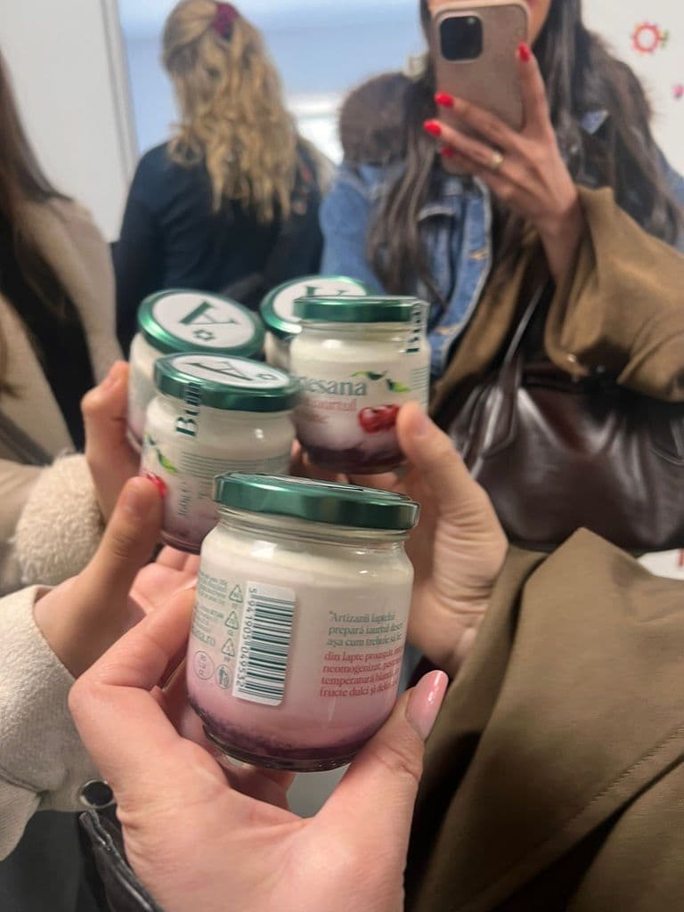 Un borcan de iaurt Artesana ținut în mână, la finalul vizitei în fabrică