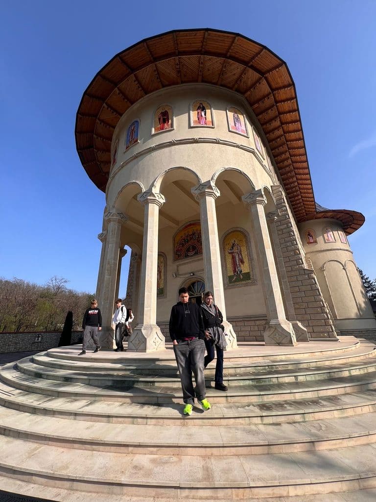 Biserica-monument văzută de jos, cu turnul rotund și coloanele albe