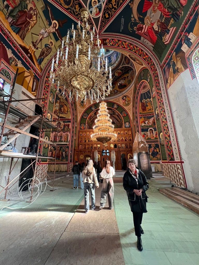 Interiorul bisericii, cu candelabru mare și iconostas pictat