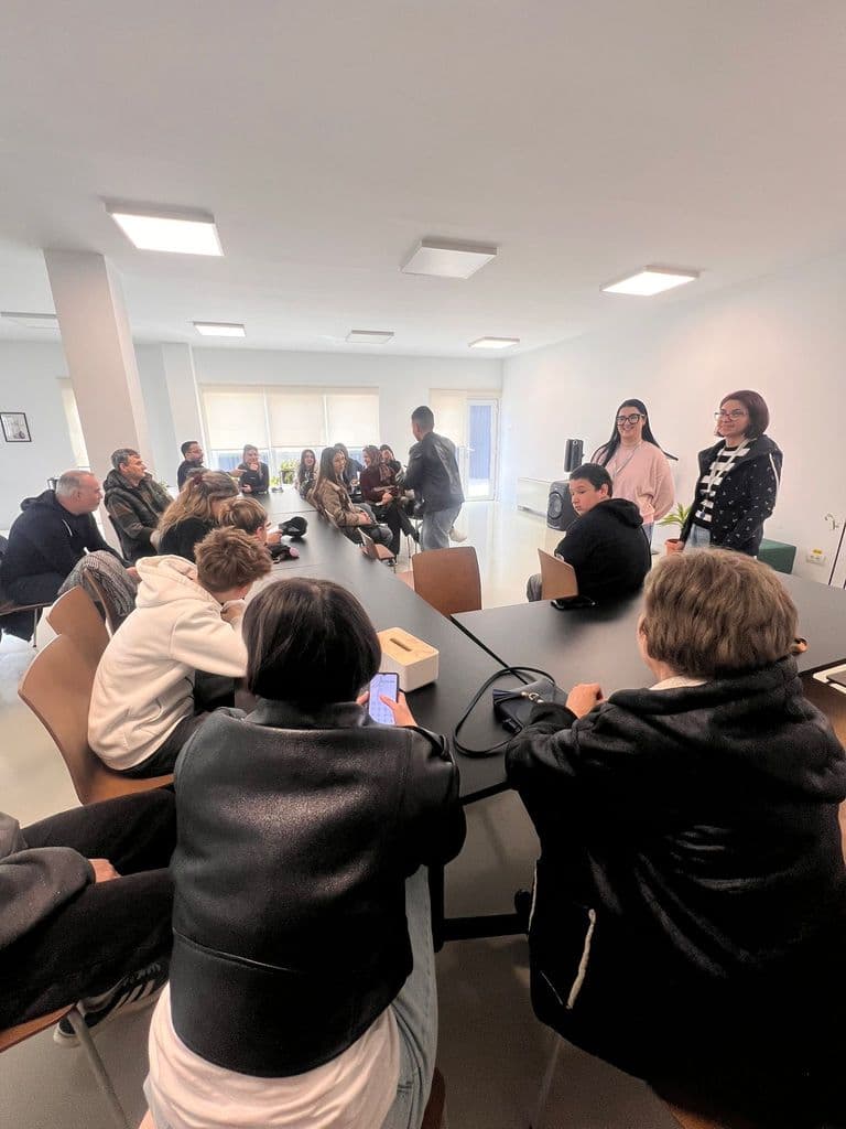Participanții așezați la mese, în timpul unei activități din program