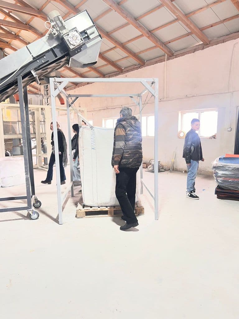 Utilaj de ambalare și un sac industrial pe palet, în hala fabricii