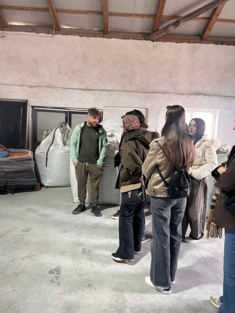 Elevi ascultând explicații în hala de producție