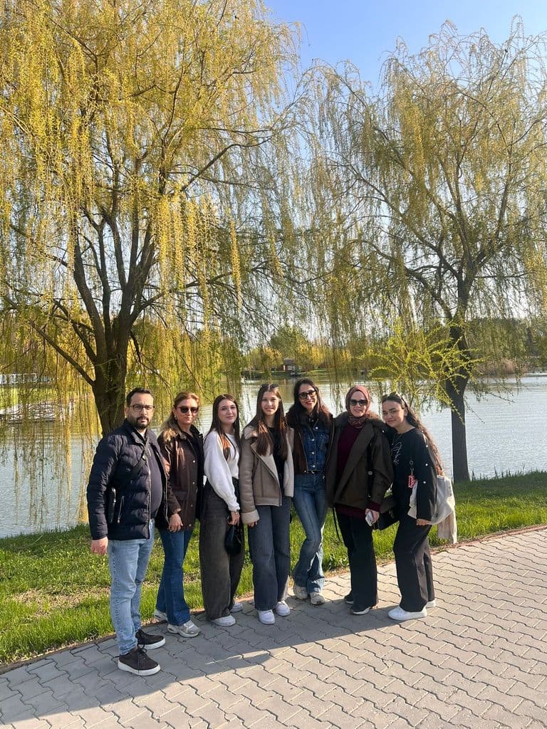 Elevi și profesori sub sălciile de pe malul apei