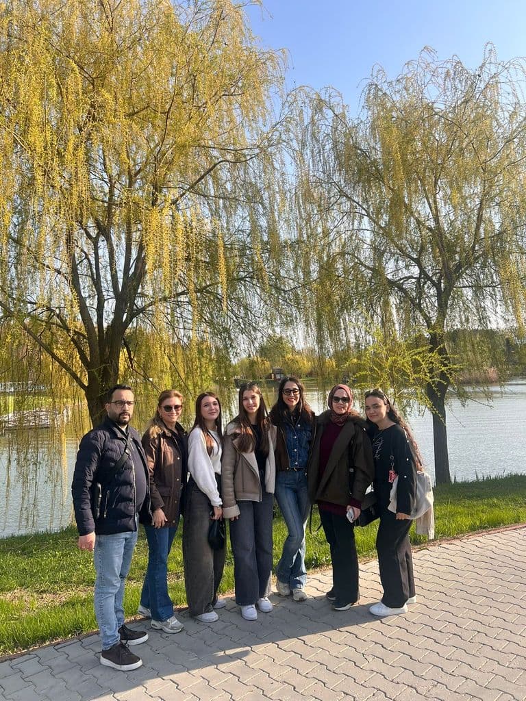 Grupul de participanți sub sălciile înverzite de pe malul apei